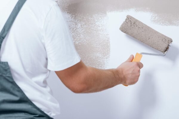 Close-up,Of,Handyman,Holding,A,Roller,In,His,Hand,And